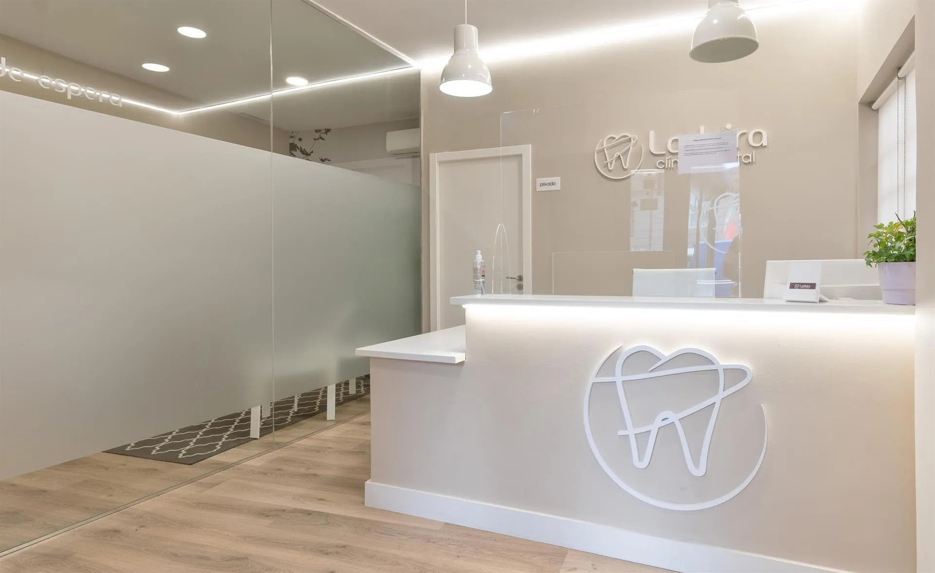 Recepción de Clínica Dental Ladeira en Baiona con el logotipo de la clínica y la sala de espera
