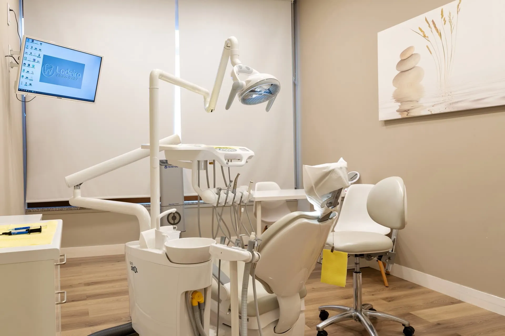 Gabinete de Clínica Dental Ladeira con sillón dental y el logotipo de la clínica en la pantalla